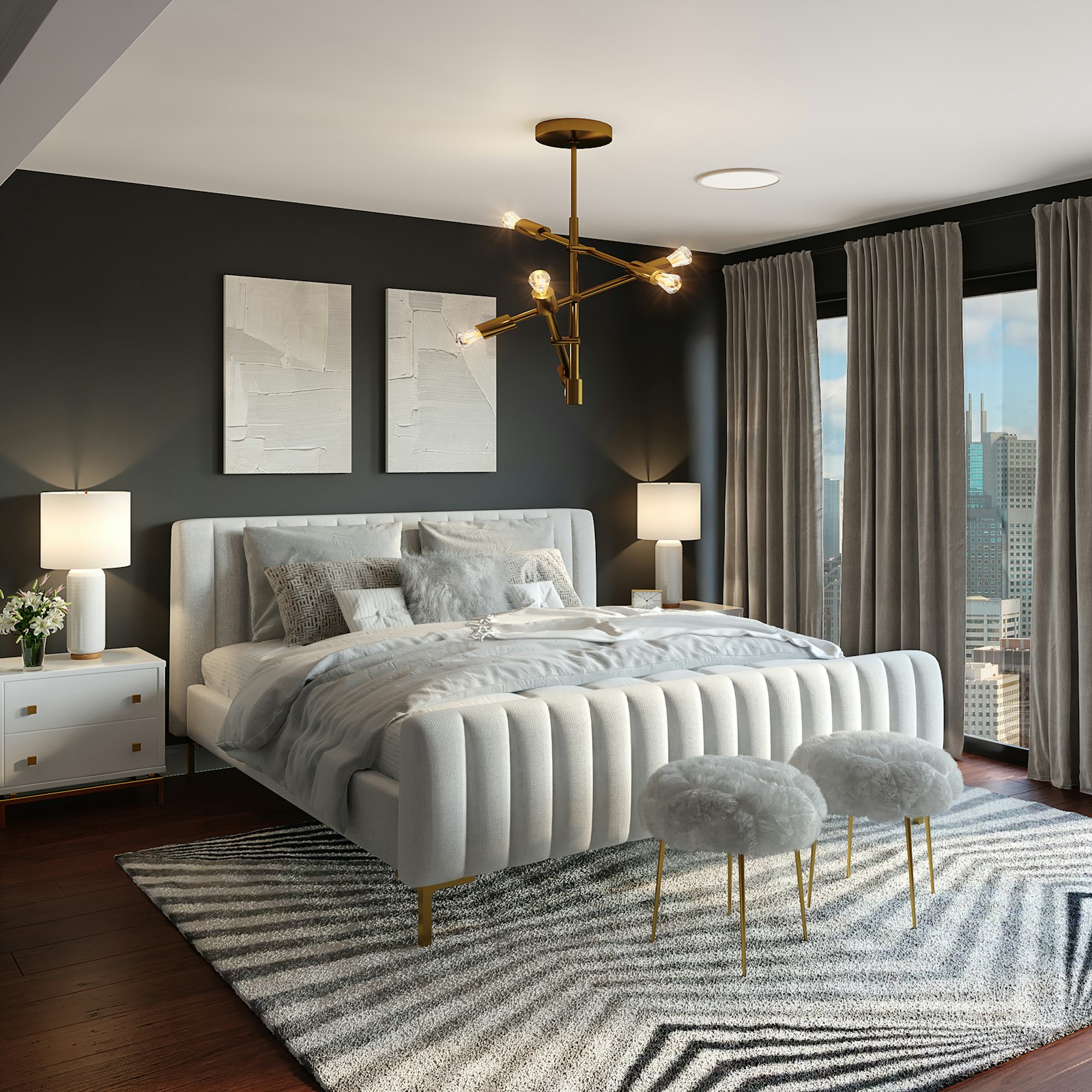 A pale upholstered bed in a dark bedroom with a brass chandelier